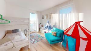a bedroom with a bunk bed and a blue chair at HEIMATEL - Ferienhaus im Alpenblick in Primisweiler