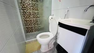 ein Badezimmer mit weißer Toilette und Waschbecken in der Unterkunft Pousada Zen in Angra dos Reis + 30 Fotos