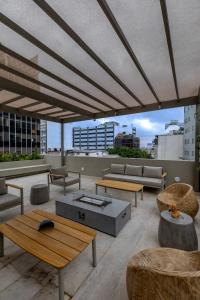 a patio with tables and couches on a roof at Capitalia Reforma Chapultepec in Mexico City
