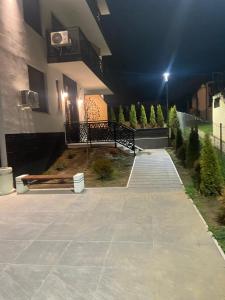 a building with a bench in a courtyard at night at Apartmani Anonim in Vrdnik +11 photos
