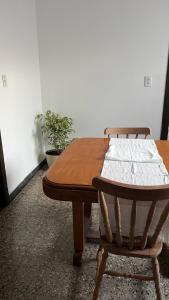 a wooden table and two chairs sitting next to a table at Departamento a media cuadra de la plaza principal in Tandil