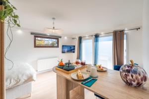 ein Wohnzimmer mit Tisch und Bett in der Unterkunft Appartement Poisy calme et résidentielle parking gratuit in Poisy