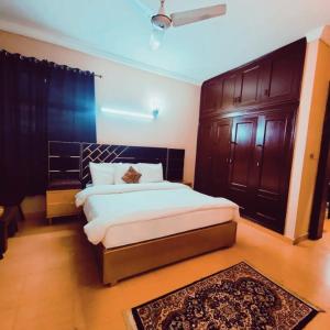 a bedroom with a large bed and wooden cabinets at Cottage Inn in Faisalabad