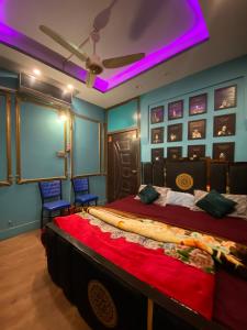 a bedroom with a large bed with purple lighting at Cottage Inn in Faisalabad
