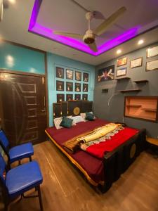 a bedroom with a large bed and a piano at Cottage Inn in Faisalabad