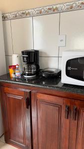 eine Küchentheke mit einer Mikrowelle und einer Kaffeemaschine in der Unterkunft Casa de Veraneio Paraty in Paraty