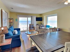 a living room with a blue couch and a table at Ocean Dunes 306 in Kure Beach