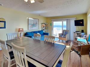a living room with a table and a blue couch at Ocean Dunes 306 in Kure Beach +43 photos