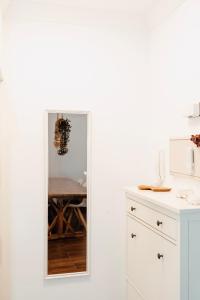 a white kitchen with a table and a mirror at Casa Oceanchild - Terraza con Vista Mar, Morro Jable in Morro del Jable +20 photos