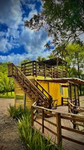 a building with a wooden deck and a yellow building at Pousada Quinta das cores in Urubici