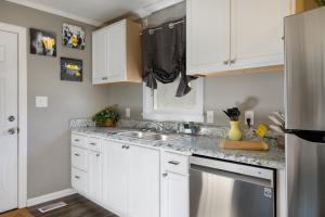 a kitchen with white cabinets and a sink at Cozy Vintage Ranch in Fayetteville +8 photos