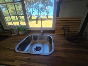 a kitchen sink with a faucet in front of a window at The Country Nook in Manildra +49 photos