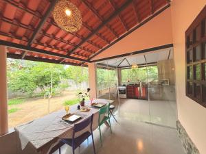 een keuken en eetkamer met een tafel en stoelen bij Chalé Pequi, Romântico e espaçoso, com ar cond conforto e aconchego in Cavalcante