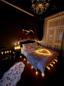ein Schlafzimmer mit einem Bett mit Lichtern und einem Kronleuchter in der Unterkunft Apartment Secret Place in Lwiw