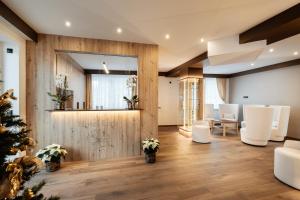 een lobby met een kerstboom en witte stoelen bij Apartment Hotel Elvis in Ortisei