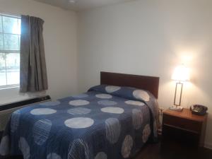 Un dormitorio con una cama y una lámpara y una ventana. en My Town Extended Stay, en Rome