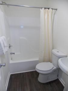 Un baño blanco con inodoro y ducha. en My Town Extended Stay, en Rome