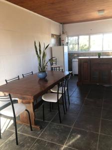 eine Küche mit einem Holztisch und Stühlen sowie eine Küche mit einem Kühlschrank in der Unterkunft Hogar de luz in Olavarría