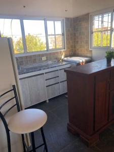 eine Küche mit einer Theke, einem Tisch und Stühlen in der Unterkunft Hogar de luz in Olavarría + 1 Foto