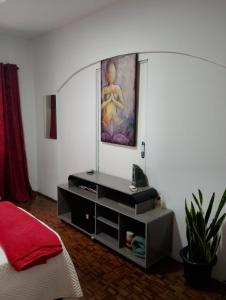 Un dormitorio con un tocador con una pintura en la pared en Zen Maharani Guesthouse - Qt nº 2, en Bauru