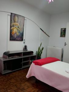 Un dormitorio con una cama y un cuadro en la pared. en Zen Maharani Guesthouse - Qt nº 2, en Bauru