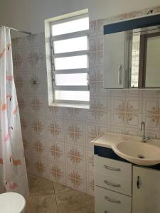 een badkamer met een wastafel en een spiegel bij Casa de praia ideal para relaxar in Torres