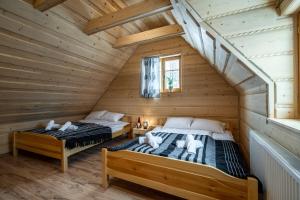 Giường trong phòng chung tại Domek u Świerków 2 - Zabytkowe domki 4 i 8 osobowe, w każdym 2 sypialnie, 2 łazienki, aneks kuchenny, balkon, 1,5km Termy Chochołowskie +83 ảnh