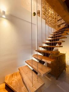 a wooden staircase with glass railings and wooden tables at Al Foér Guesthouse in Averara