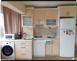 a kitchen with a white refrigerator and a sink at AFİFE Apart, Kusadasi,Denize ve Plaja Sıfır in Kuşadası