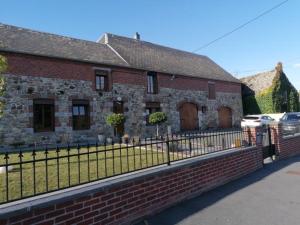 une maison en briques avec une clôture devant elle dans l'établissement La ferme des souvenirs 3, à Felleries