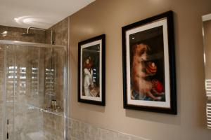 a bathroom with two pictures of a dog on the wall at Blue Bell Country Inn in Knaresborough +26 photos