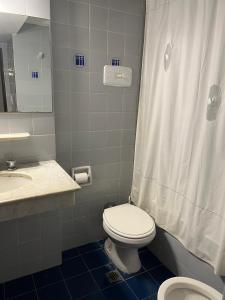 a bathroom with a toilet and a sink and a shower at 3Reyes in Necochea