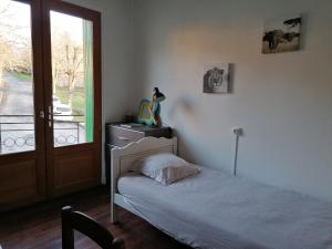 a bedroom with a bed and a window and a door at Chaleur des bois du Quercy in Montcuq