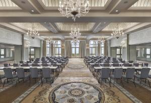 um salão de banquetes com mesas, cadeiras e lustres em Casa Del Mar em Los Angeles