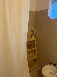 a bathroom with a toilet and a shower curtain at Departamento a media cuadra de plaza central in Tandil