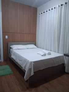 a bedroom with a bed with two towels on it at Apartamento moderno próximo ao centro in União da Vitória +4 photos