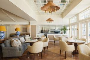 una sala de estar con sofá, mesas y sillas en Shutters On The Beach, en Los Ángeles