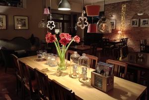 a table with pink flowers in a vase on it at Hotel Stare Miasto Old Town in Poznań