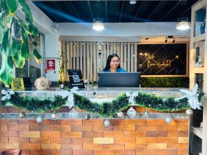 a woman standing behind a counter with a laptop at Hostal Bon Hábitat in Yopal +100 photos
