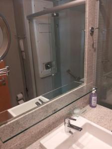 ein Badezimmer mit Waschbecken und großem Spiegel in der Unterkunft Flat Sofisticado no Jade Hotel Home Office in Brasilia