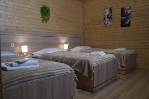 two beds in a room with wooden walls at Wooden Villa Sormoni in Tskaltubo +32 photos