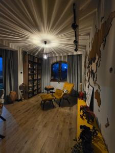 a living room with a yellow chair and a table at Loft Haven - Loftowa Przystań in Trzemeszno