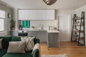 a living room with a green couch and a kitchen at Chic Georgian Escape near Royal Crescent in Bath +29 photos