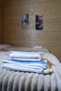 a stack of towels sitting on top of a bed at Wooden Villa Sormoni in Tskaltubo