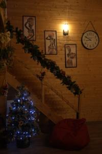 a staircase with a christmas tree and a clock at Wooden Villa Sormoni in Tskaltubo