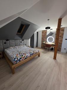 een slaapkamer met een bed in een kamer met een zolder bij Loft Haven - Loftowa przystań in Trzemeszno +62 foto's