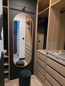 een kleedkamer met een spiegel en een kruk bij Loft Haven - Loftowa przystań in Trzemeszno