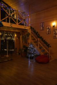 a christmas tree in a room with a staircase at Wooden Villa Sormoni in Tskaltubo