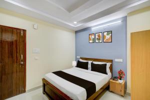 Un dormitorio con una cama grande en una habitación. en Townhouse Financial District Circle Hyderabad, en Gundipet