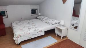 a small bedroom with a bed and a mirror at Apartment Dalma in Podgora